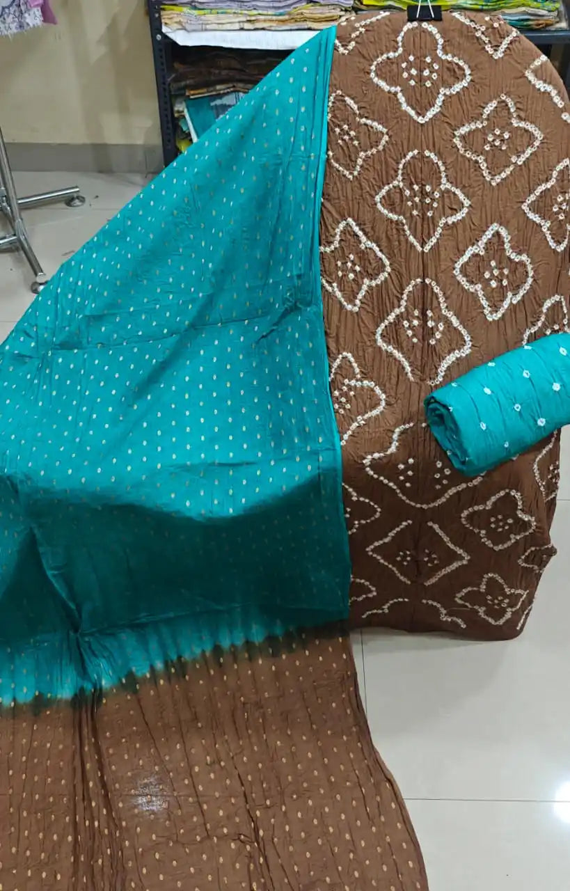 Classic mud-brown cotton bandhani suit material showcasing elegant floral-shaped tie-dye designs, styled with a bright contrast turquoise blue dupatta.