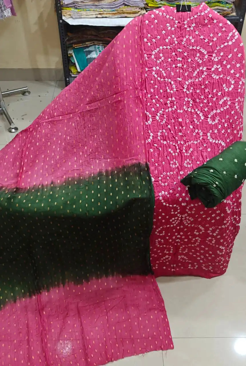 Bright magenta pink unstitched bandhani suit fabric featuring rich geometric tie-dye patterns, styled with a deep bottle green contrast dupatta.