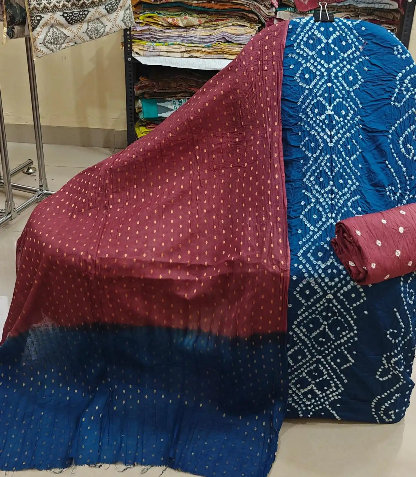 Royal blue cotton bandhani dress material with distinctive circular tie-dye patterns, styled with a deep teal-green contrast dupatta.
