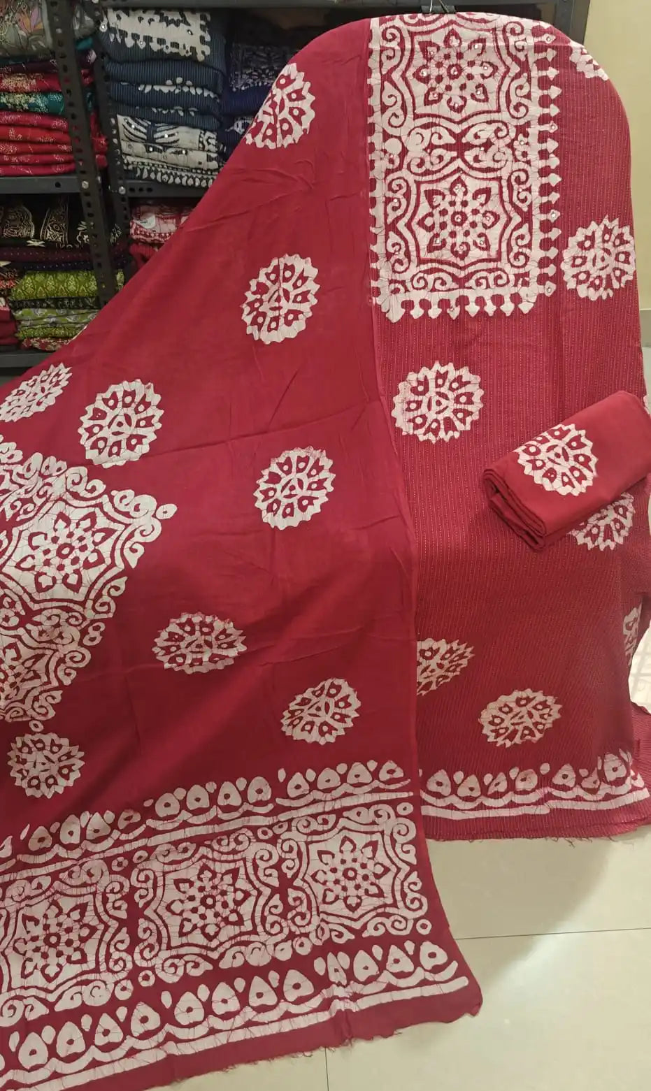 Bold crimson red unstitched cotton batik suit material showing intricate white square panel artwork presented by ASC Fashion Store.