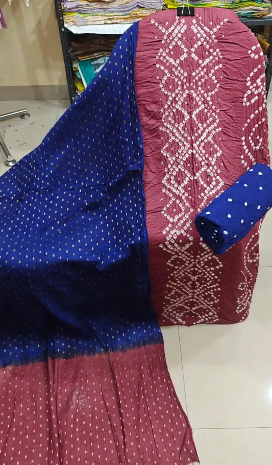 Rich maroon unstitched cotton bandhani dress material with white geometric tie-dye embroidery patterns, paired with a vibrant royal blue contrast dupatta featuring small golden checks.