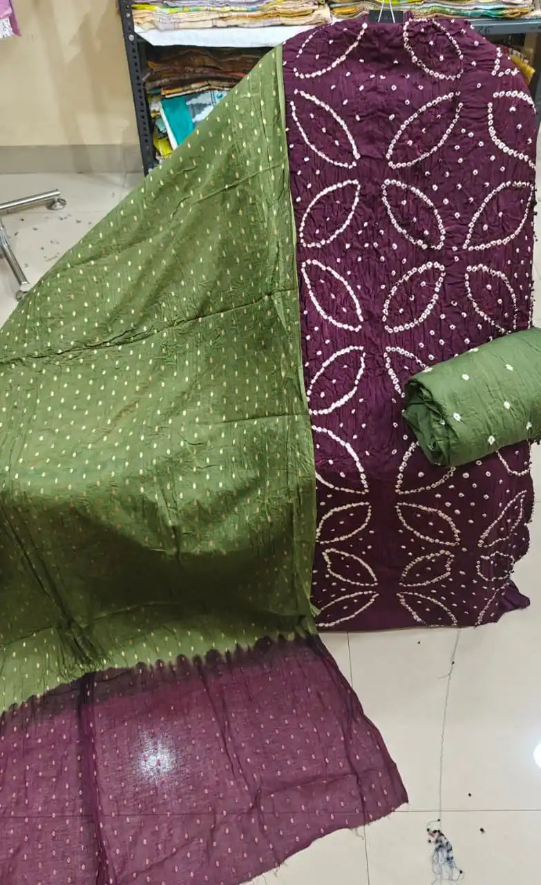 Deep wine-colored cotton bandhani dress material showcasing bold oval tie-dye rings, paired beautifully with an olive green contrast dupatta.