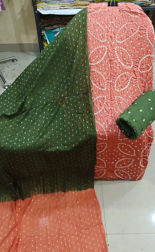 Soft peach-pink cotton bandhani suit fabric featuring intricate white tie-dye leaf patterns, accompanied by a dark olive green contrast dupatta.