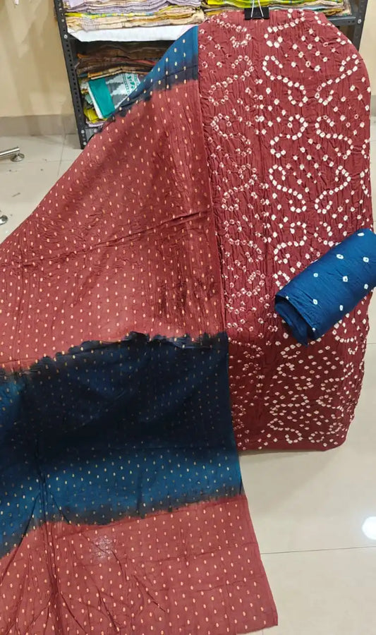 Traditional deep maroon bandhani dress material paired gracefully with a contrast teal blue dupatta featuring delicate golden foil prints.