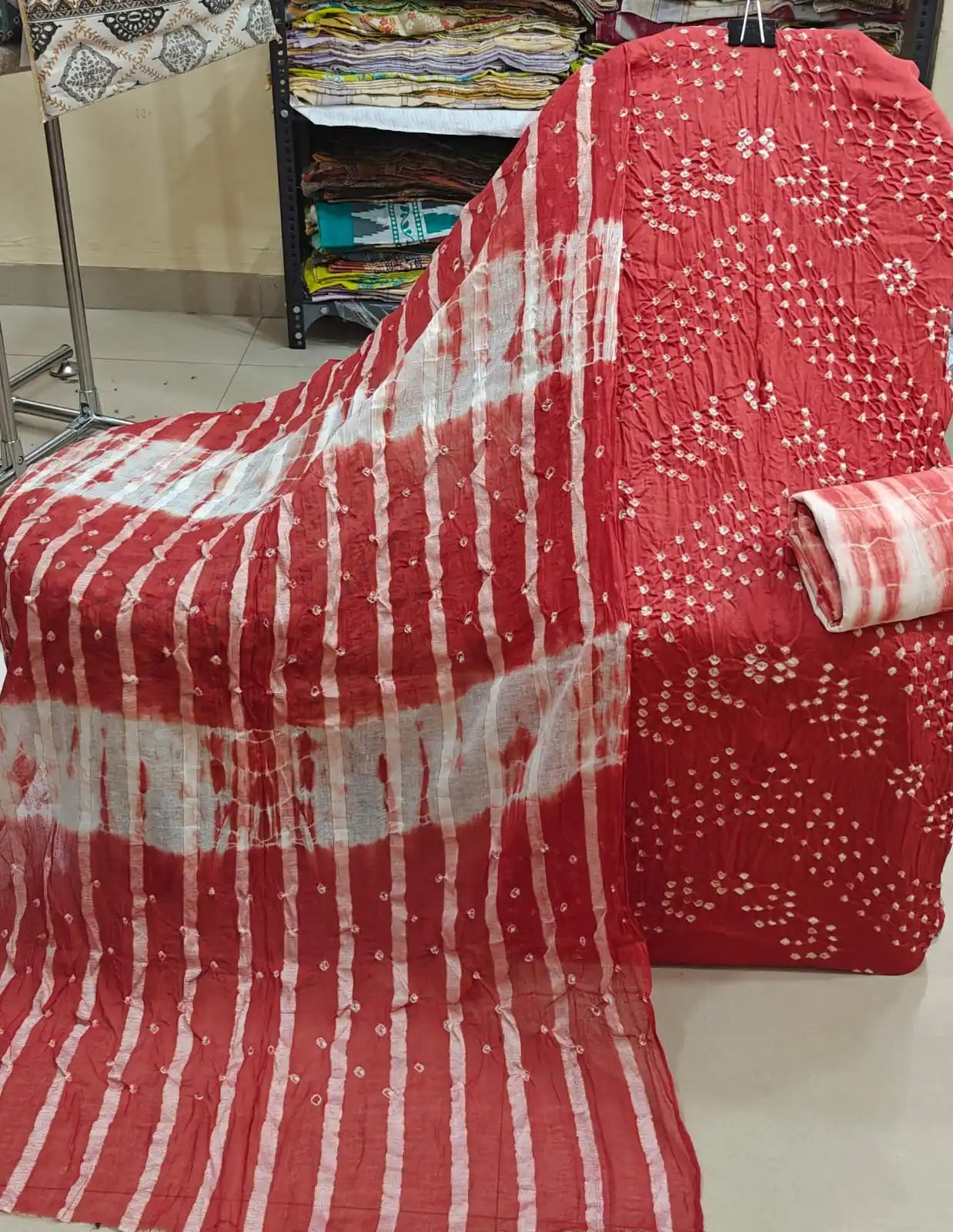 Soft peach-pink cotton bandhani suit fabric featuring intricate white tie-dye leaf patterns, accompanied by a dark olive green contrast dupatta.
