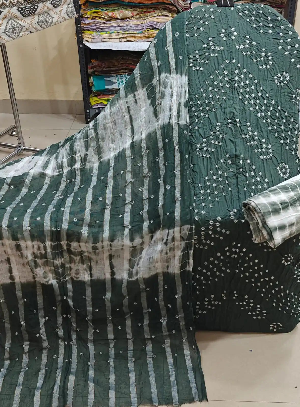 Dark olive green unstitched cotton bandhani suit fabric featuring a delicate sprinkle of white tie-dye dots, styled alongside a matching green and white tie-and-dye striped dupatta.