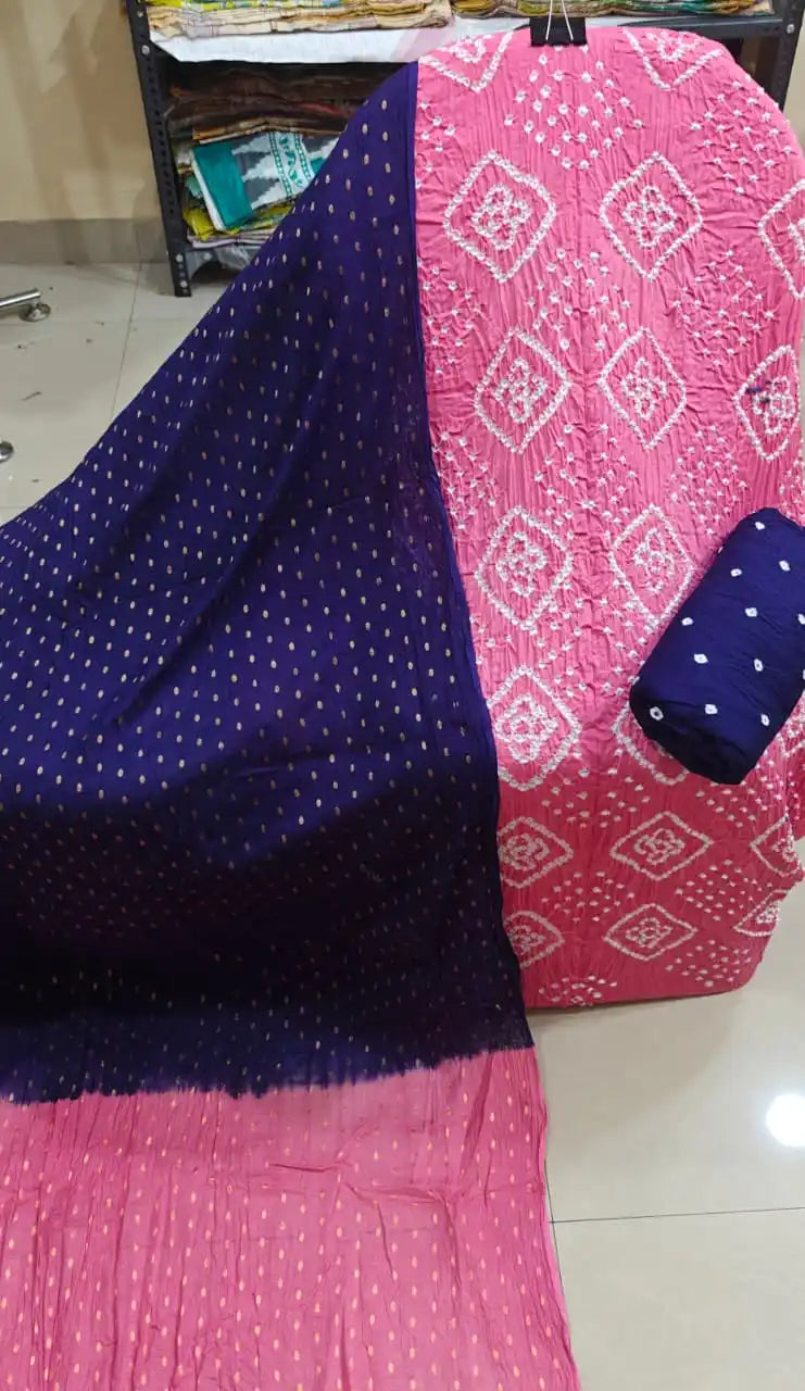 Graceful pink cotton bandhani dress material with diamond tie-dye patterns, paired with a dark indigo blue dupatta decorated with gold bootis.
