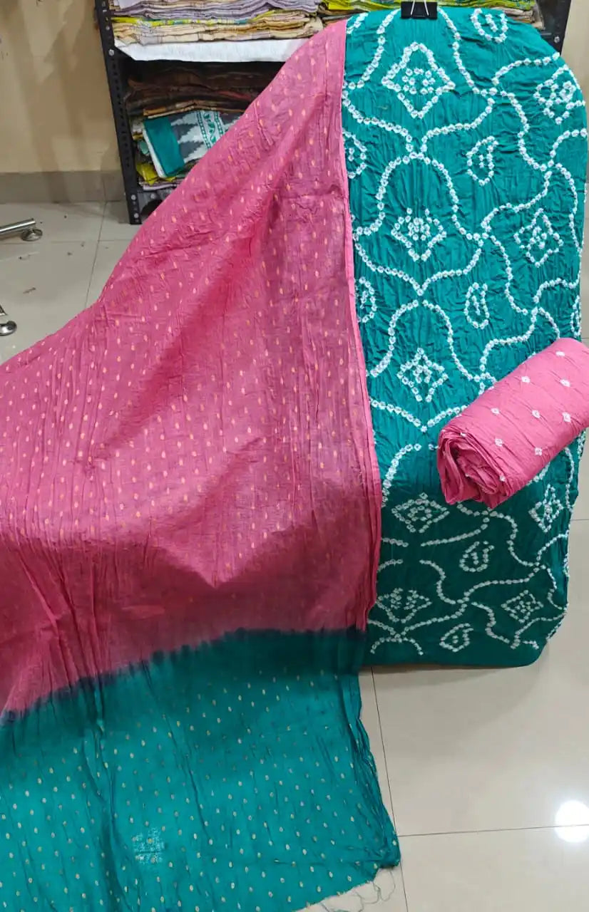 Vibrant teal green unstitched bandhani suit material displaying white traditional motifs, complemented by a soft pink contrast dupatta.