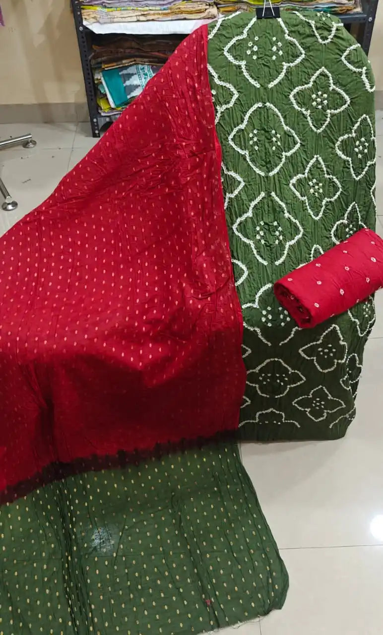 Earthy olive green cotton bandhani dress material featuring white leaf-shaped tie-dye patterns and a rich dark red contrast dupatta.