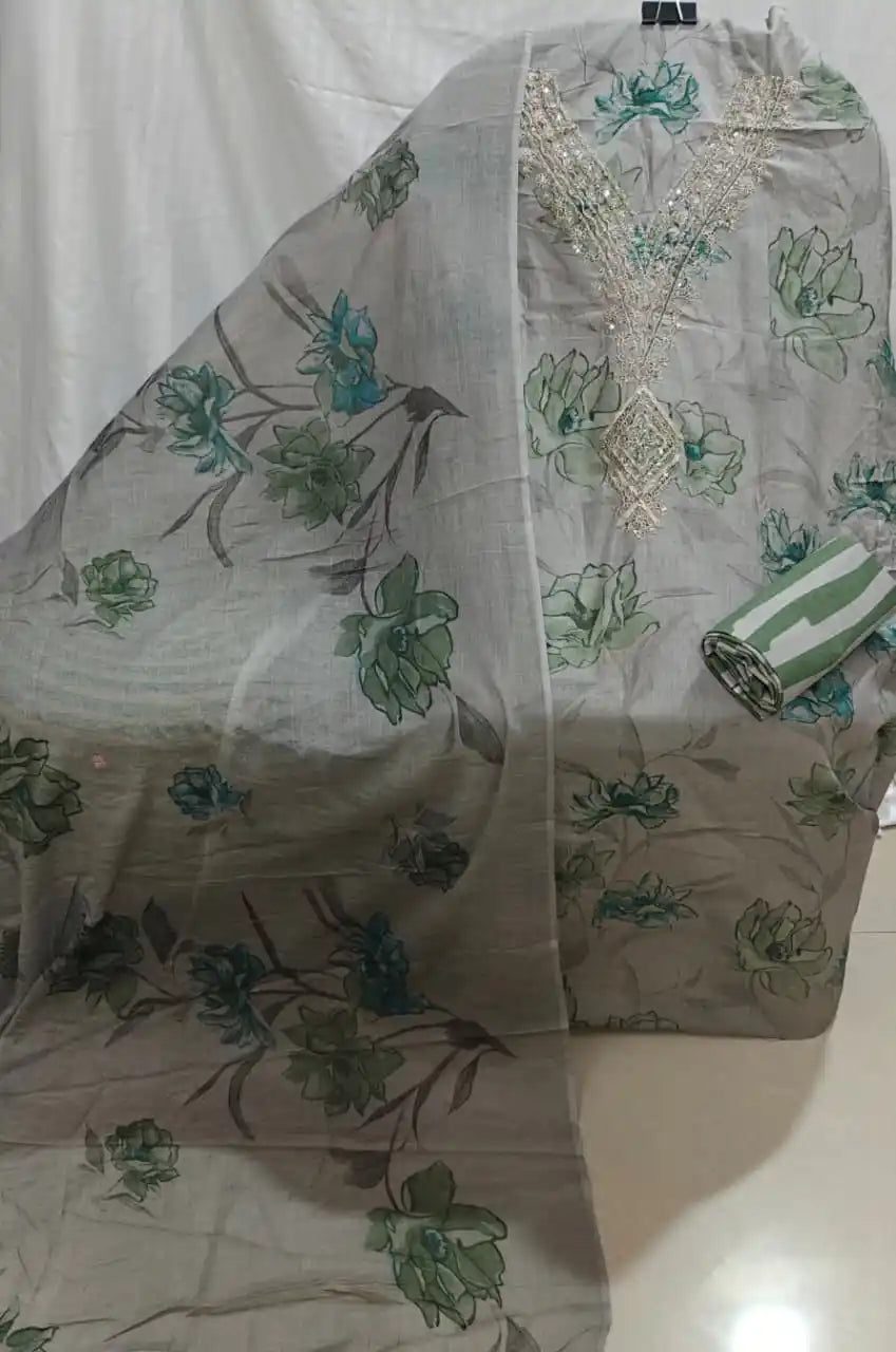 A premium grey cotton unstitched dress material by ASC, showcasing large dark green and blue floral prints, a delicate silver V-neck embroidery patch, and a matching soft grey dupatta.