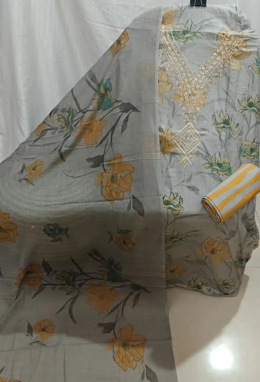 A stylish grey cotton unstitched suit fabric by ASC, featuring oversized golden-yellow flowers, an embroidered cream V-shape neck detail, and a coordinated printed dupatta.