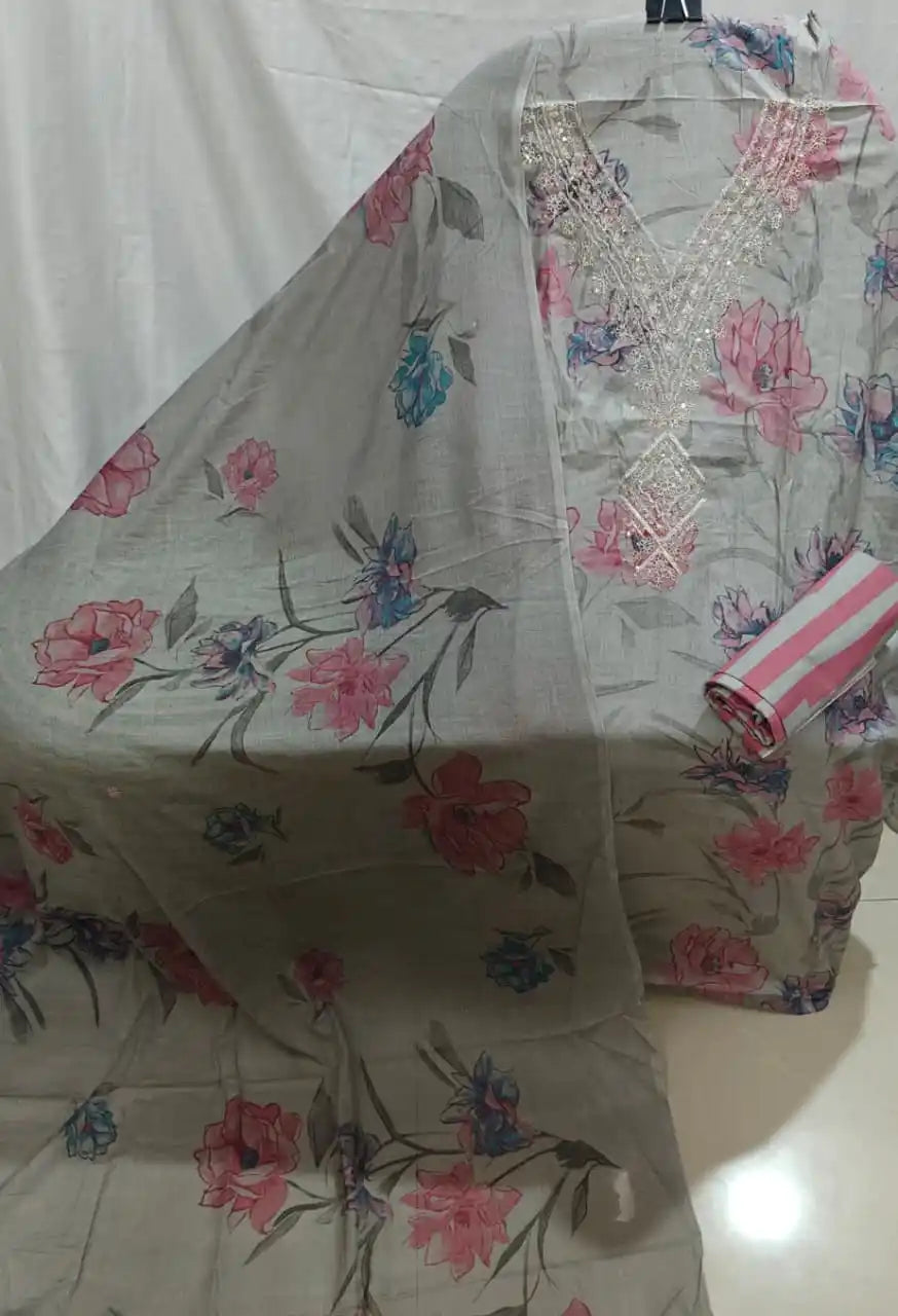 A flat lay view of a grey cotton unstitched dress material by ASC, decorated with large pink rose prints, a fine embroidered V-neck patch with subtle shimmer, and a matching floral dupatta.