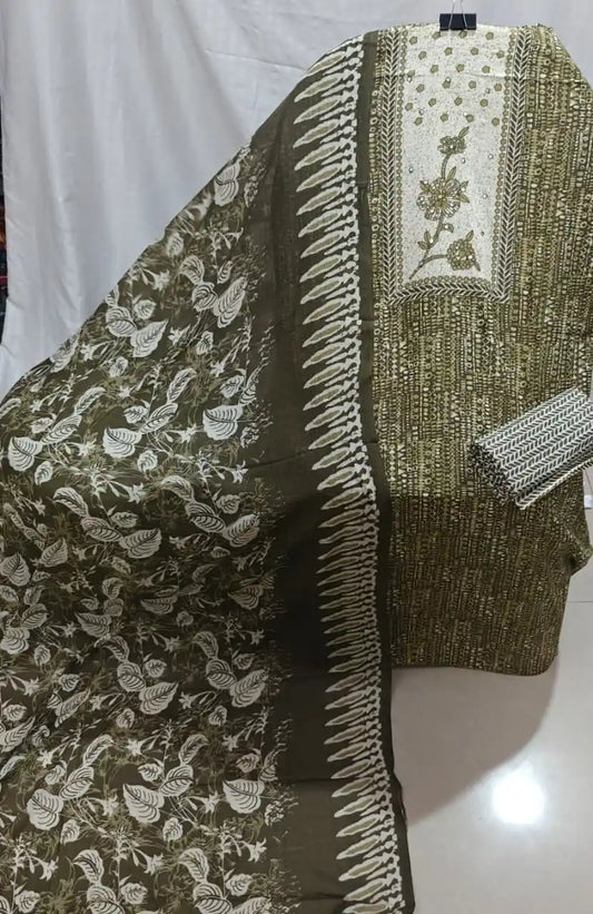 A detailed look at an olive green cotton unstitched dress material by ASC, featuring fine geometric dash prints, a prominent off-white chest panel with embroidered leafy twigs, and a dark olive dupatta with cascading leaf prints.