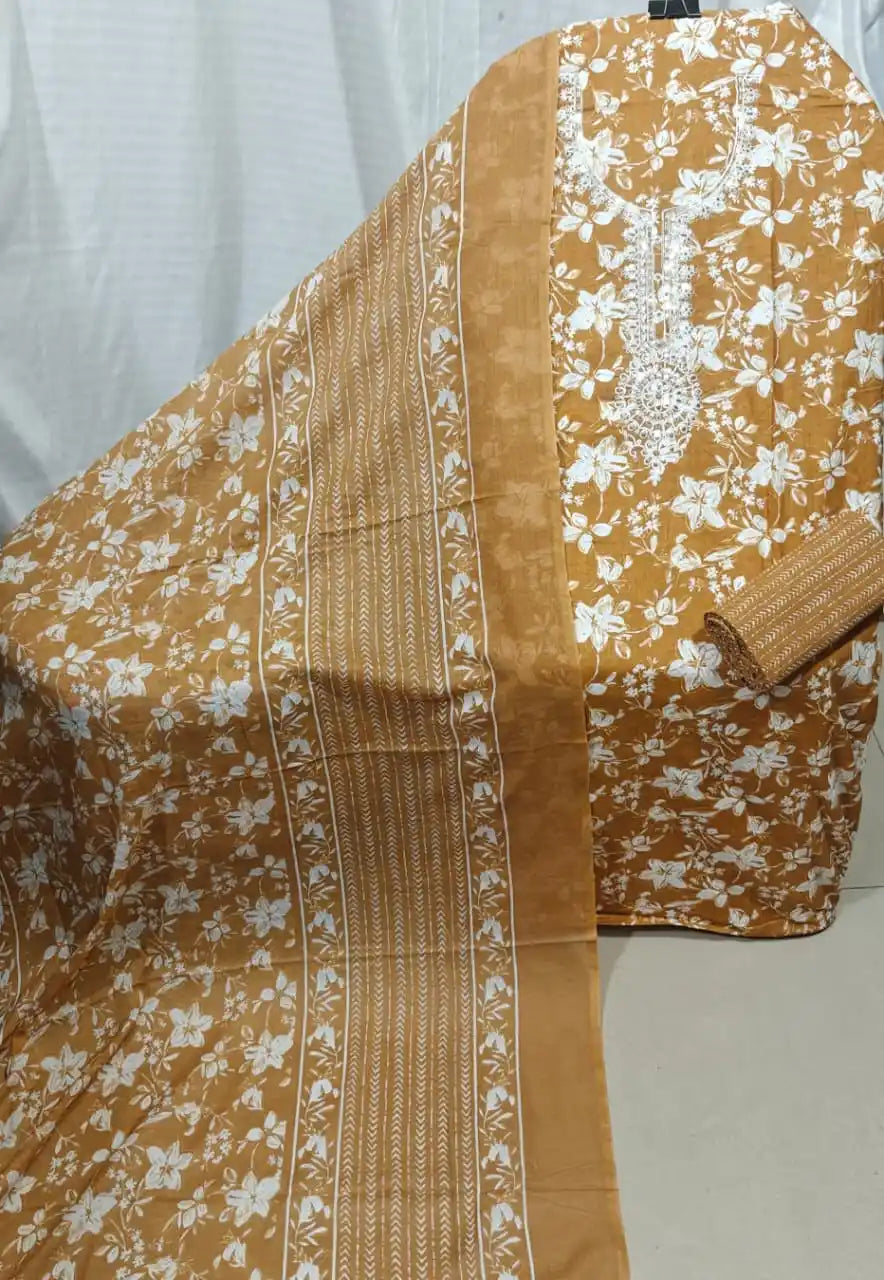 A beautiful mustard yellow cotton unstitched dress material by ASC, adorned with a crisp white floral jaal print, a heavily detailed white thread embroidery split-neck collar panel, and a matching mustard dupatta featuring striped and leafy borders.
