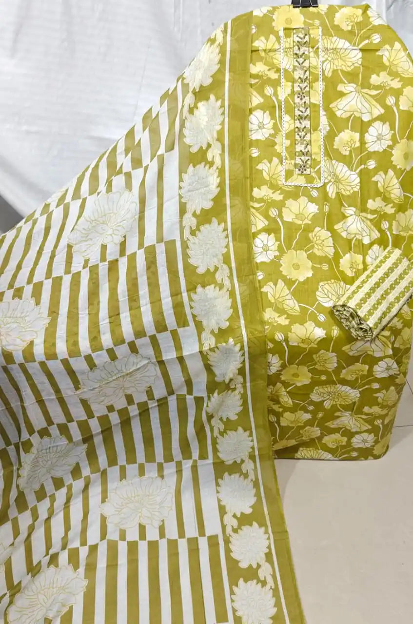 A gorgeous olive mustard yellow cotton unstitched dress material by ASC, showcasing an all-over white lotus pond print, a delicate embroidered lace neck strip, a matching small grid pattern bottom, and a coordinated white dupatta displaying broad mustard block stripes and large floral end-panels.