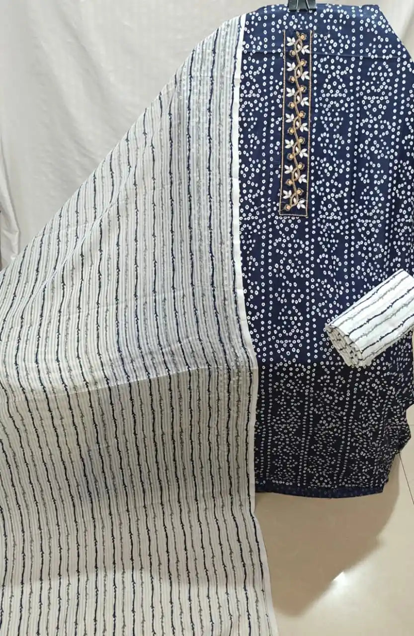 A classic navy blue cotton unstitched suit material by ASC, showcasing dense white bandhani dots across the kurta fabric, an intricate golden vine embroidered neck patch, a white bottom with navy wavy lines, and a light-colored dupatta featuring matching vertical navy stripes.