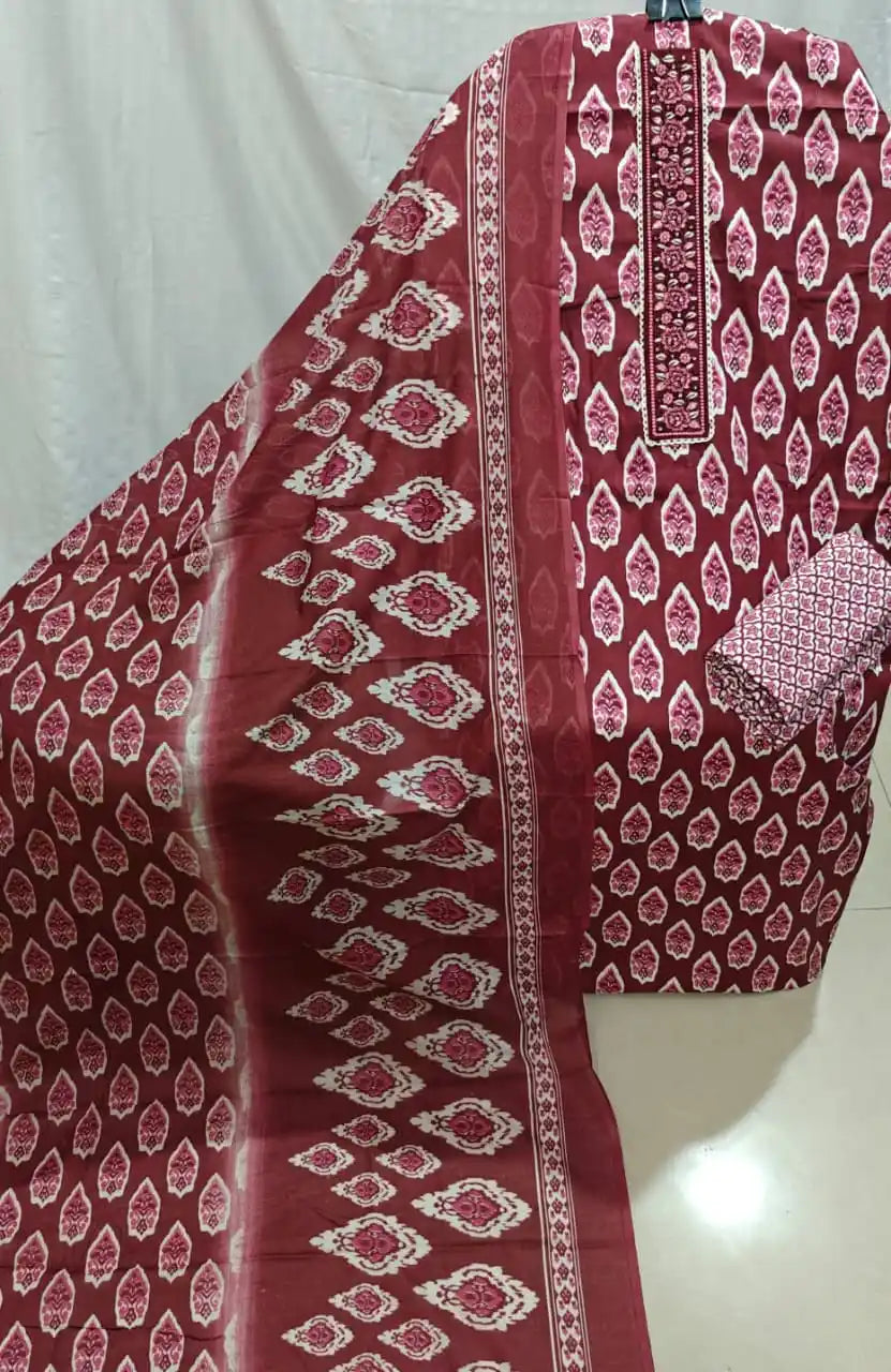 A flat lay photo of a maroon and cream cotton unstitched dress material by ASC, featuring all-over leaf motifs, an intricately embroidered neck patti, and a matching patterned dupatta.