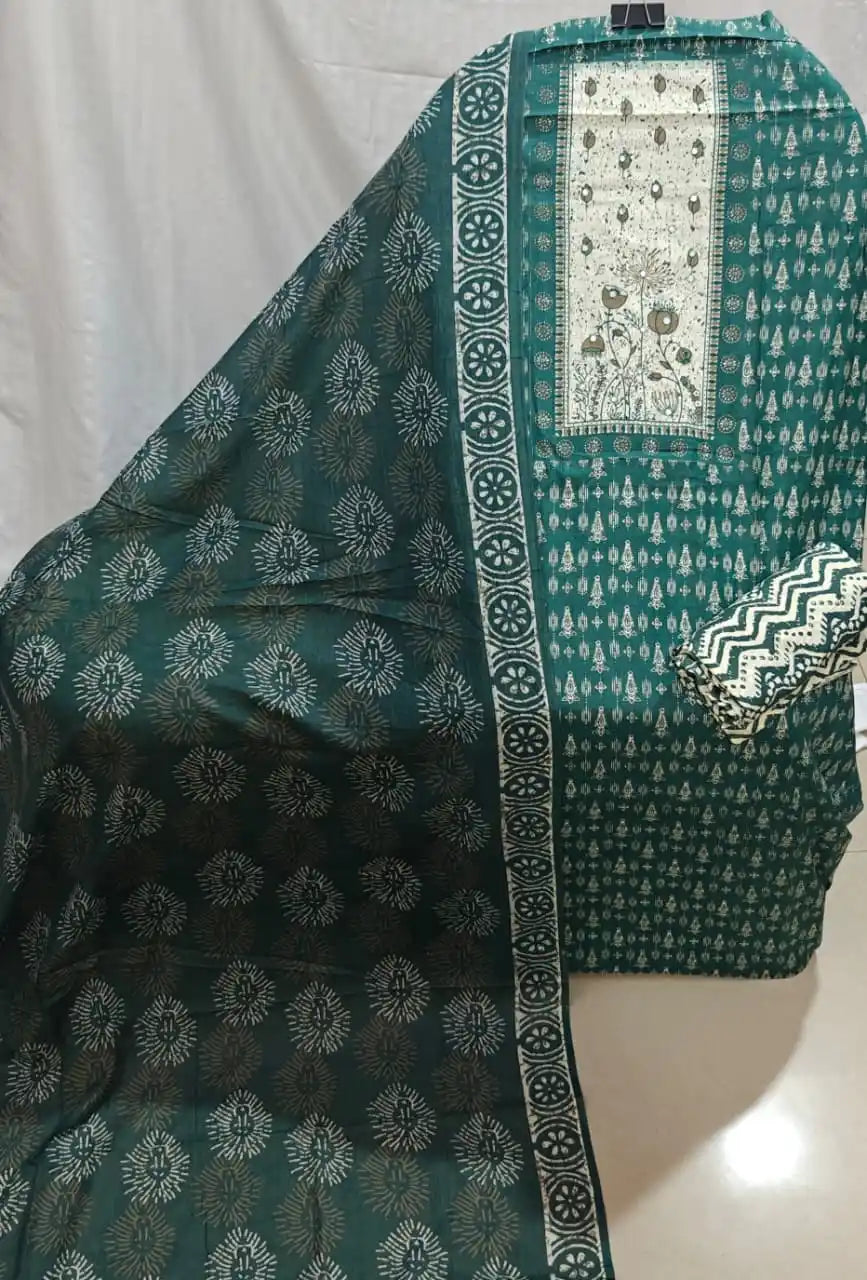 A view of a dark green cotton unstitched suit fabric by ASC, highlighting a prominent cream chest panel with embroidered flowers, all-over mini prints, and a matching printed dupatta.