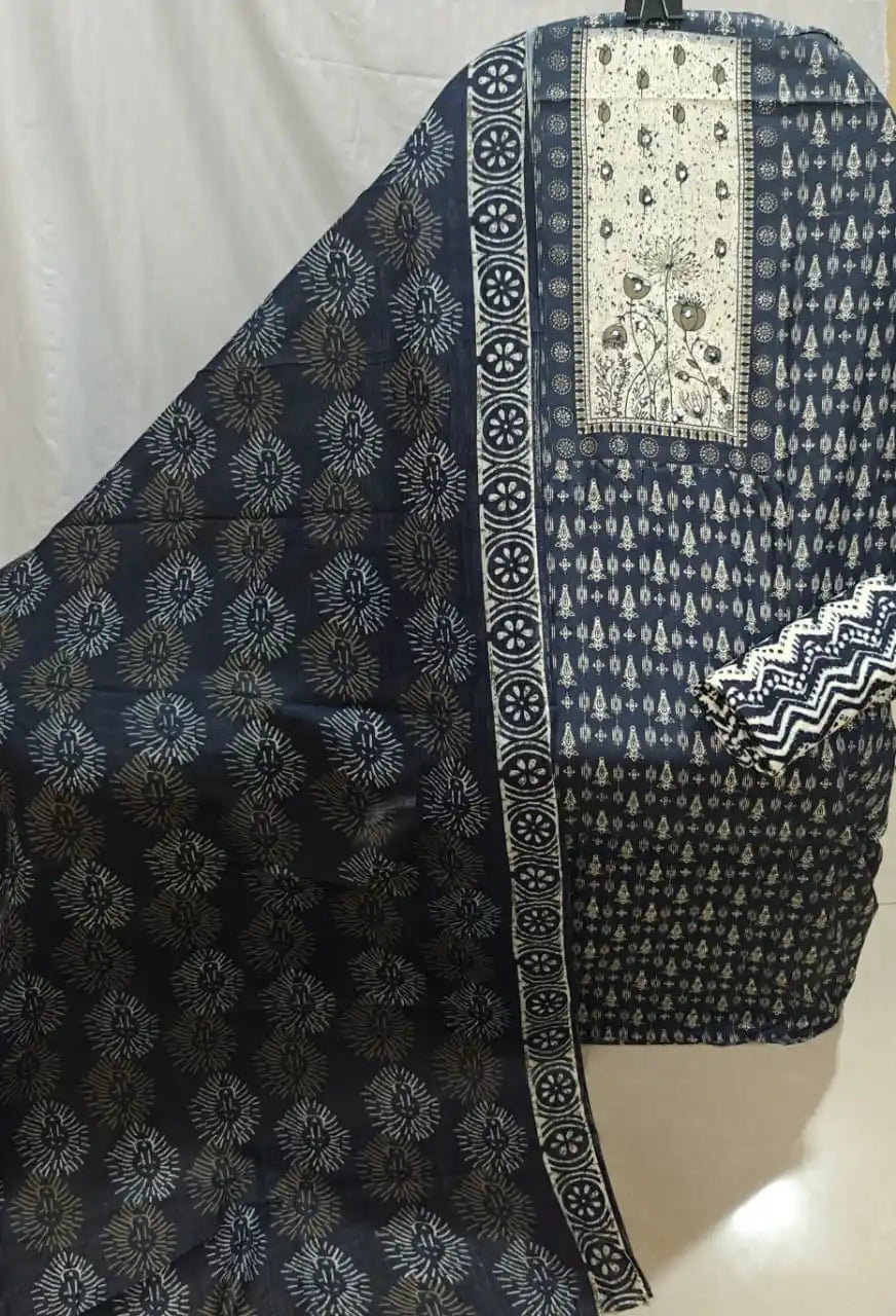 A flat lay view of a navy blue cotton unstitched dress material by ASC, featuring a contrasting off-white chest panel with embroidered floral art, small geometric motifs, and a matching patterned dupatta.