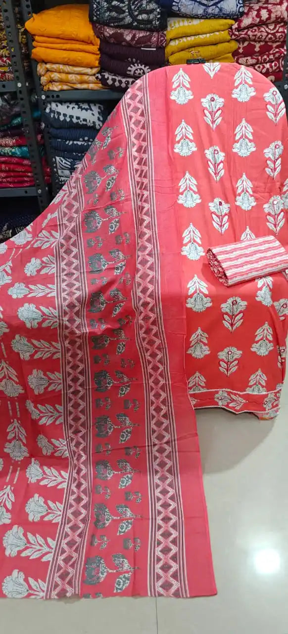 Peach orange floral suit with dupatta displayed on a rack, showcasing elegant white floral patterns and multi-bordered details.