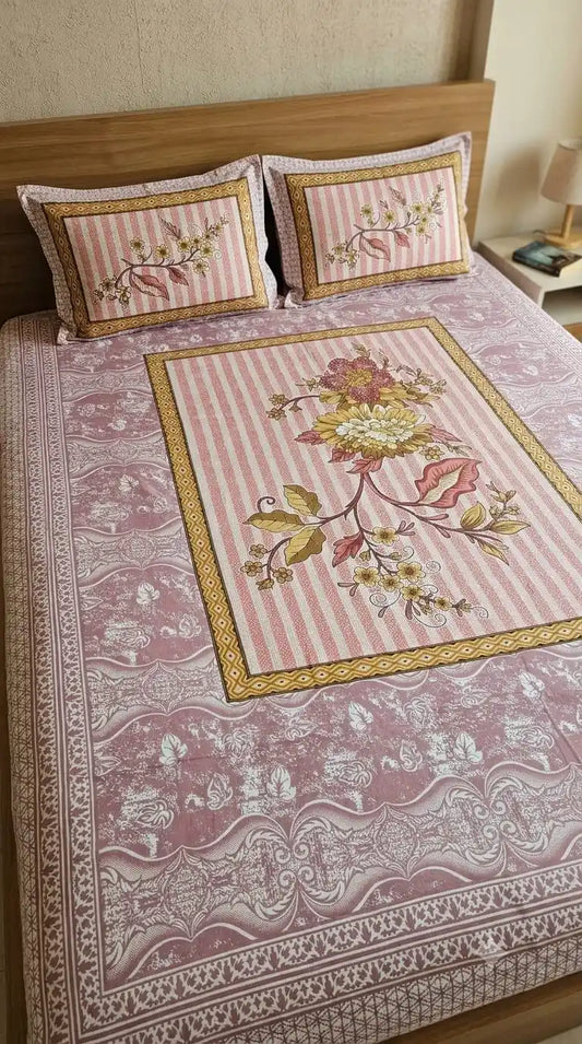 Pink petal double bedsheet set featuring intricate floral design with matching pillow covers on a bed.