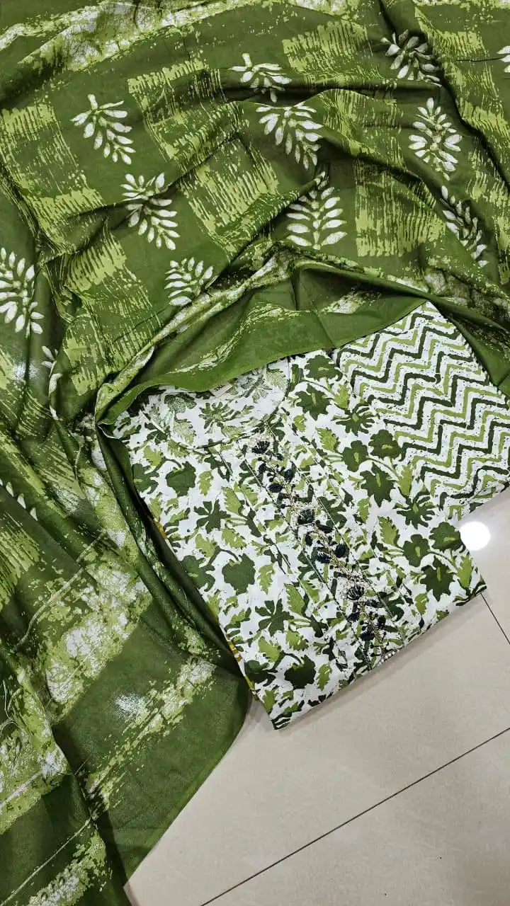 Soft cotton embroidered dailywear suit in green floral and zigzag patterns on a textured background.