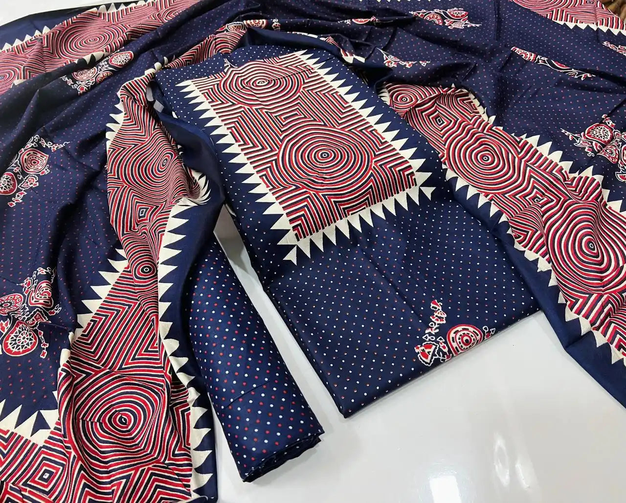 A stylish navy blue rayon unstitched dress material by ASC, featuring a micro dot base on the shirt and bottom, an eye-catching rectangular neck panel with red and off-white concentric circle prints and saw-tooth edging, paired with a matching graphic dupatta.