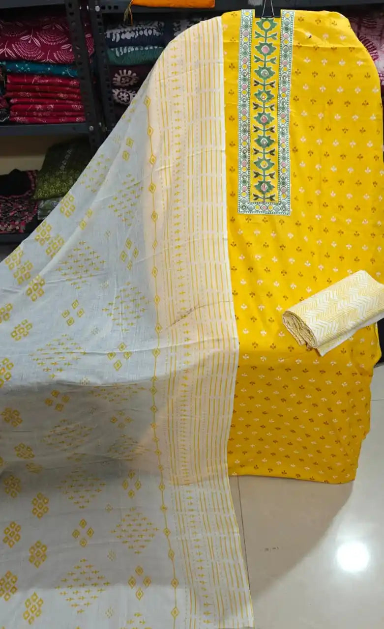 Bright yellow unstitched cotton suit displayed with matching dupatta and fabric pieces at ASC Fashion Store.