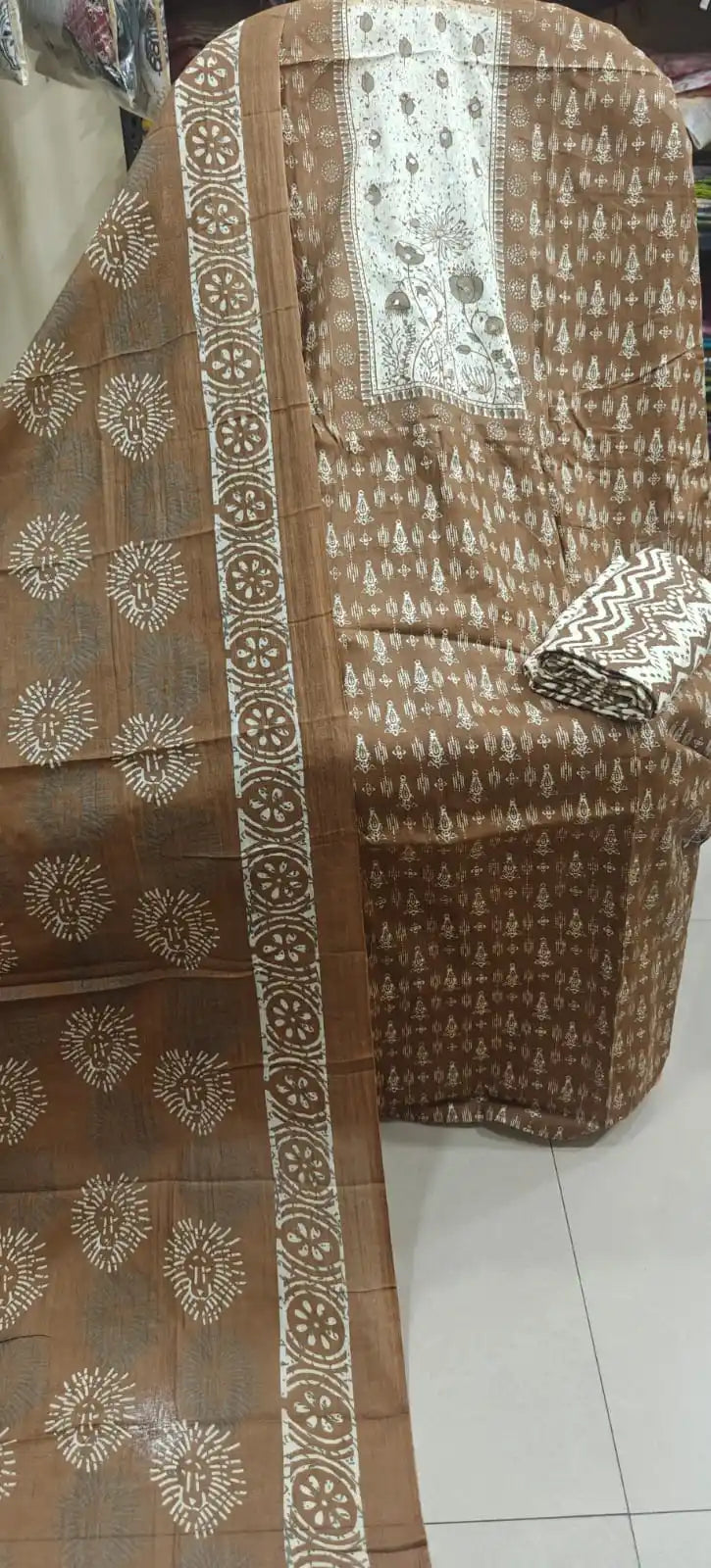 brown cotton suit highlighting a floral embroidered neck patch, matched with all-over white sunburst prints and a chevron-patterned folded bottom.