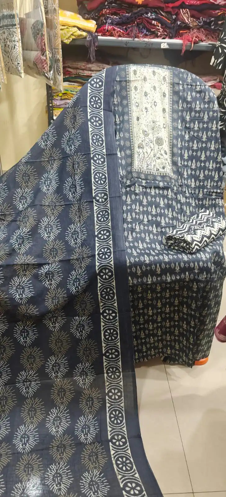 Slate blue cotton suit featuring intricate floral neck embroidery, geometric sunburst block prints, and a matching printed cotton dupatta.