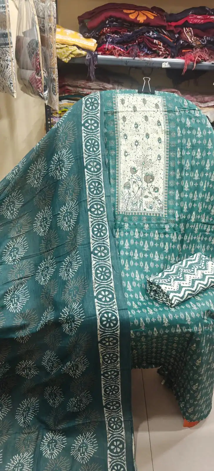 Deep green cotton suit with a contrast cream neck embroidery patch, all-over sunburst motifs, and a matching printed dupatta.