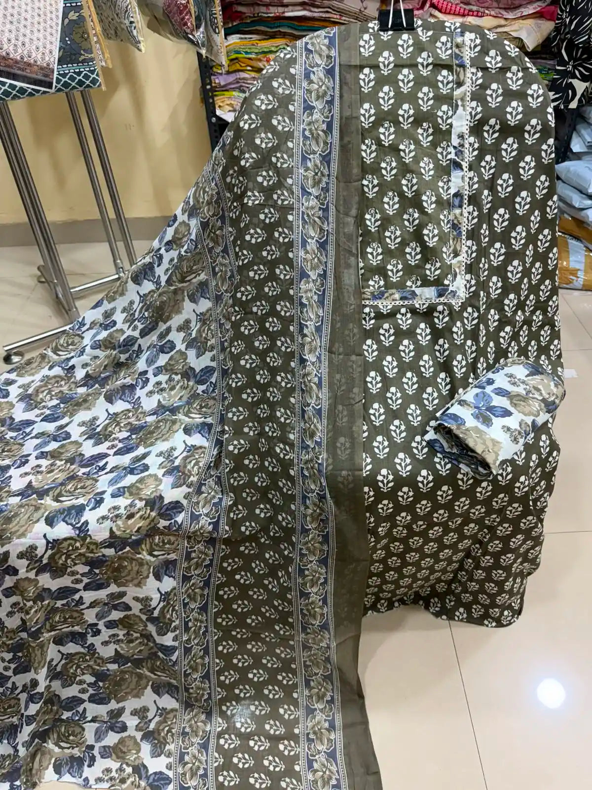 Olive green cotton suit highlighting an elegant white embroidered neck frame, all-over floral print, and a matching floral cotton dupatta.
