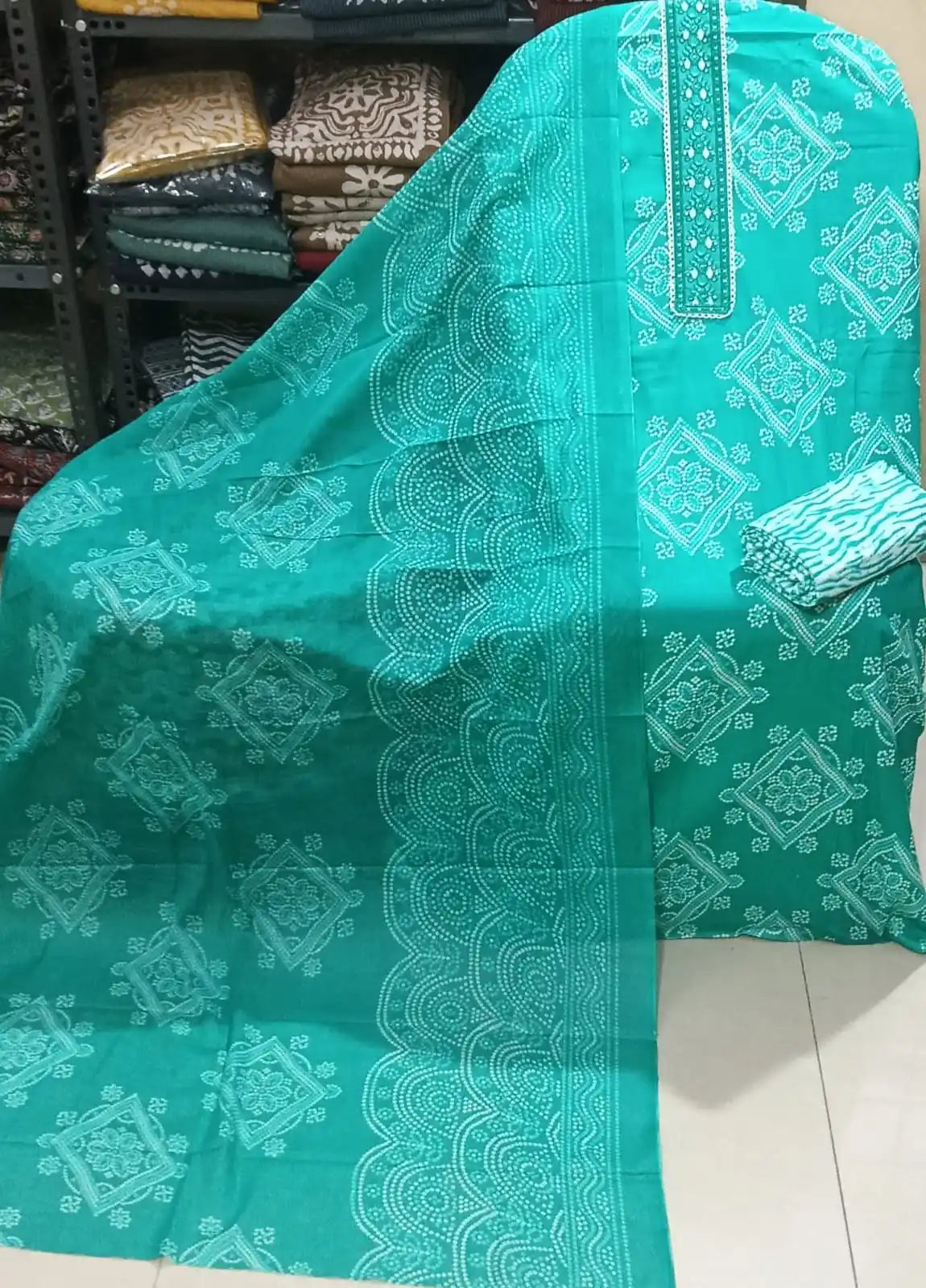 Vibrant sea green cotton suit featuring a detailed lace-bordered neck embroidery panel, ethnic white Bandhani print motifs, and a matching patterned dupatta.