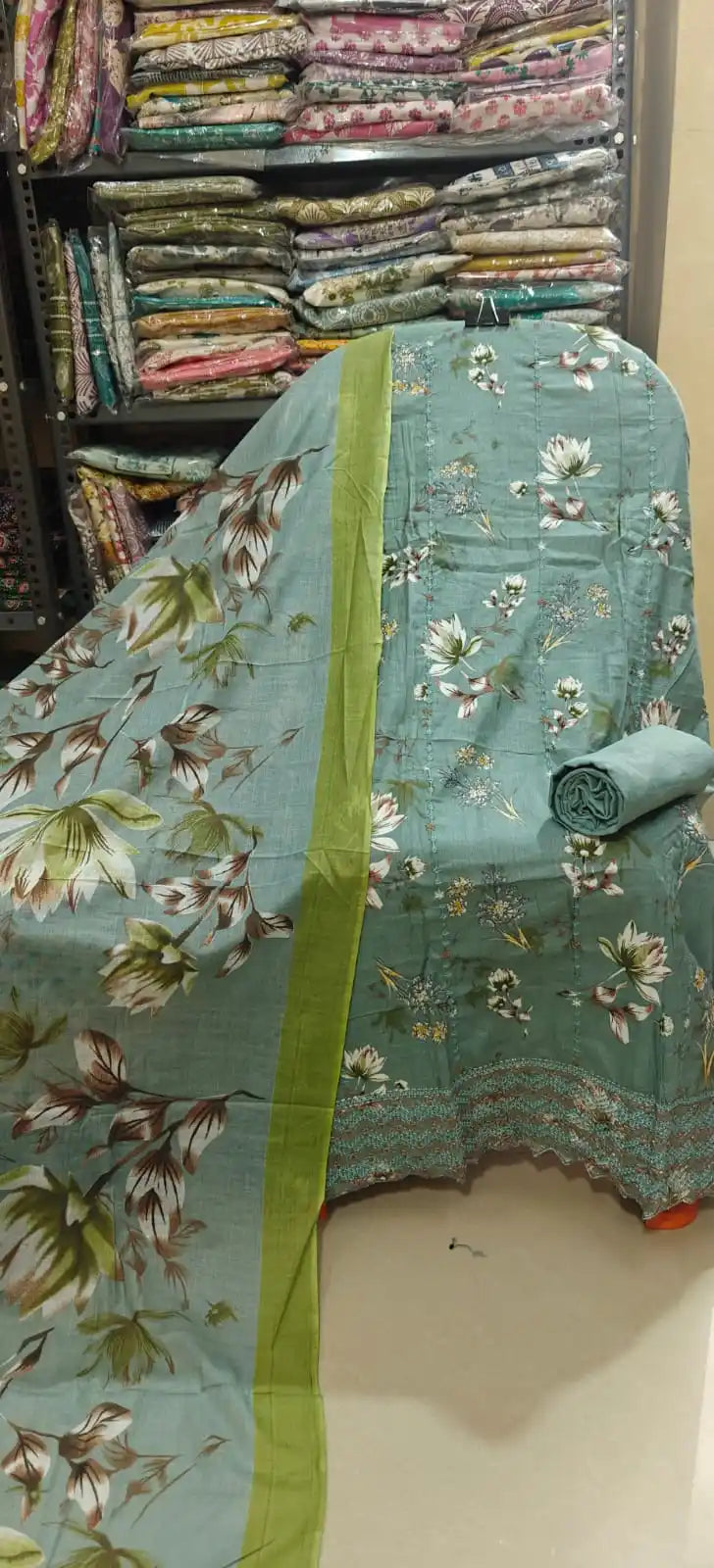 Elegant sea green cotton dress material adorned with an all-over white floral pattern, featuring a fine lace trim at the hem and a matching sea green dupatta with a striking lime green border.