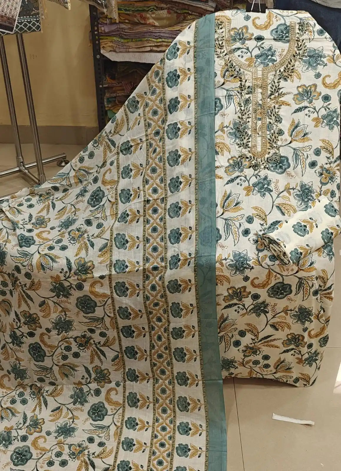 Soft cotton suit set with teal blue flower prints, an embroidered patch neck, and a matching border dupatta.