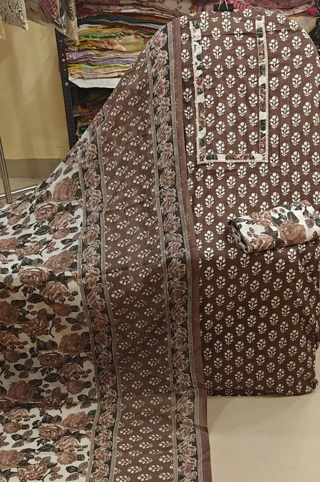 Deep brown cotton suit with small white buti prints all over and a contrasting white rose-print bottom.