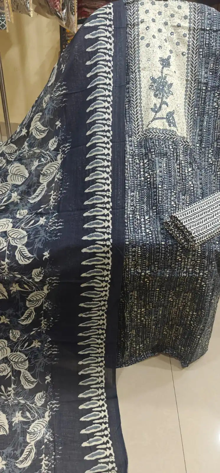 Navy blue batik print cotton suit with a white embroidered center panel and leafy patterns on the dupatta.