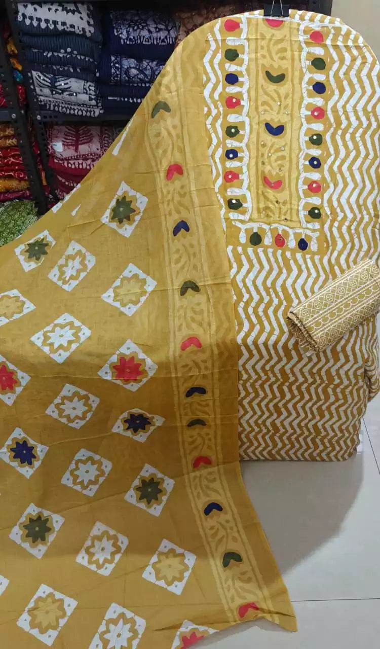 Mustard chevron print unstitched suit with mirror work displayed on a hanger.