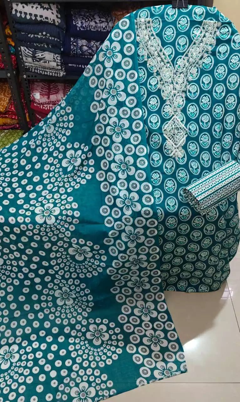 teal floral cotton suit with lace embroidery displayed on a mannequin, featuring floral ring prints and a lace-embroidered neckline.