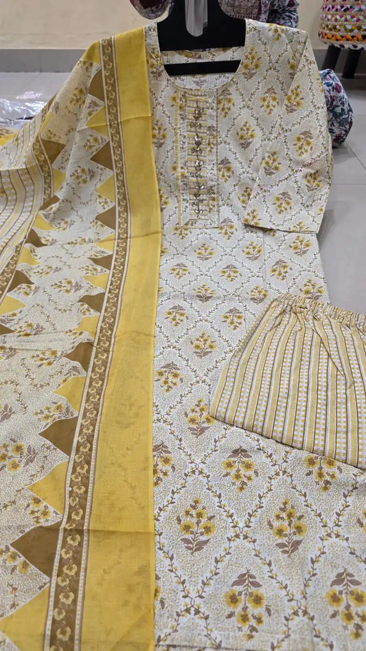 Bright yellow floral print cotton suit set with embroidered neckline and striped pants.