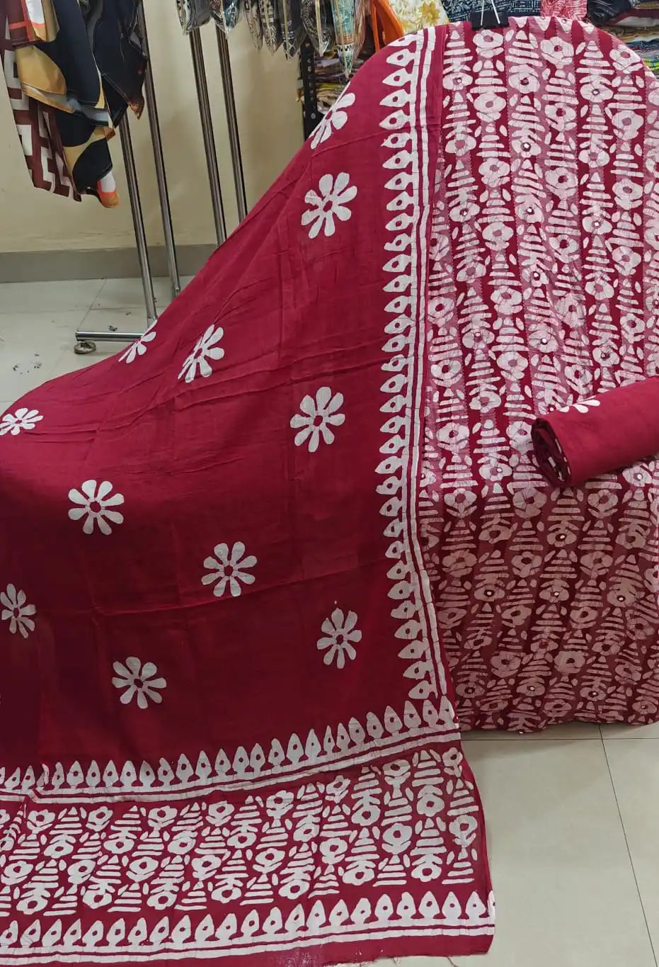 Maroon red unstitched cotton dress material with traditional white batik print layout alongside a matching dupatta showcasing floral patterns and detailed borders by ASC.