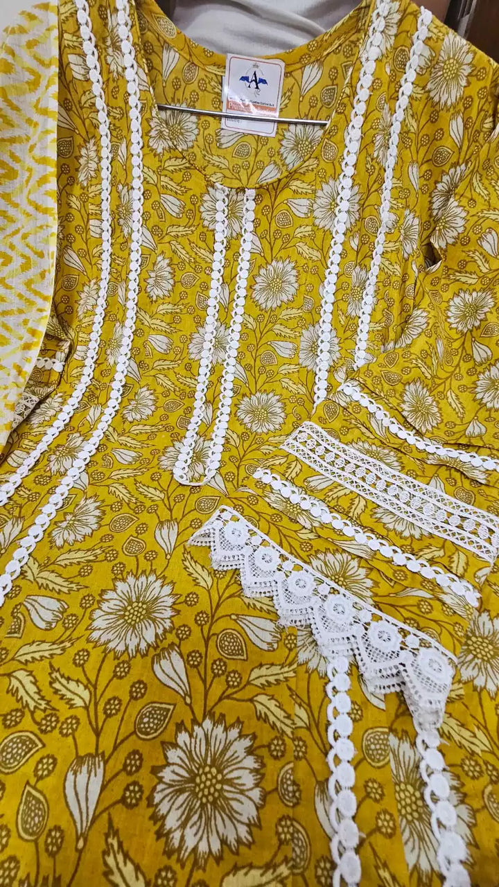 A yellow floral cotton print kurta featuring Karachi pattern with pleats work, neck potli buttons, lace detailing, and paired with a mal dupatta and cotton pant. The fabric tag is visible at the neckline.