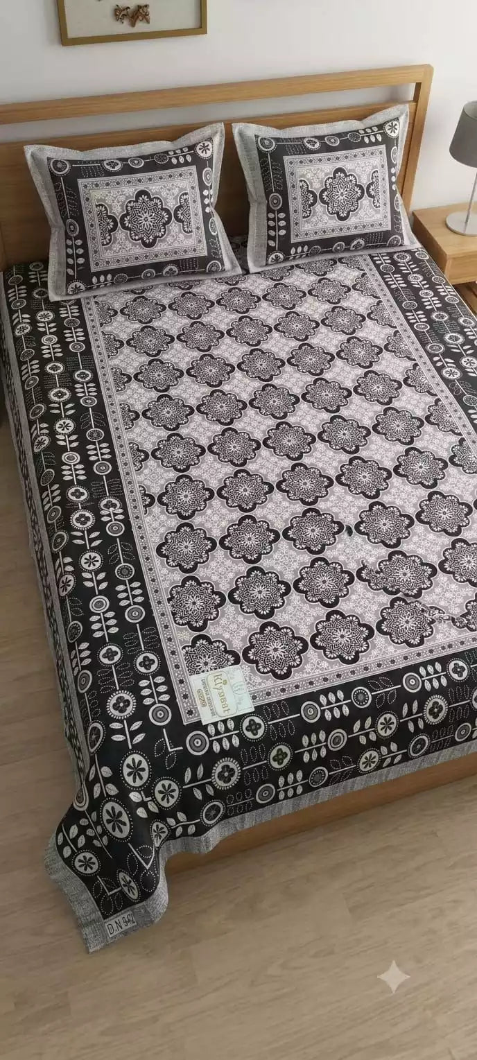 Jaipuri double bedsheet with pillow covers in black and white design displayed on a wooden bed.