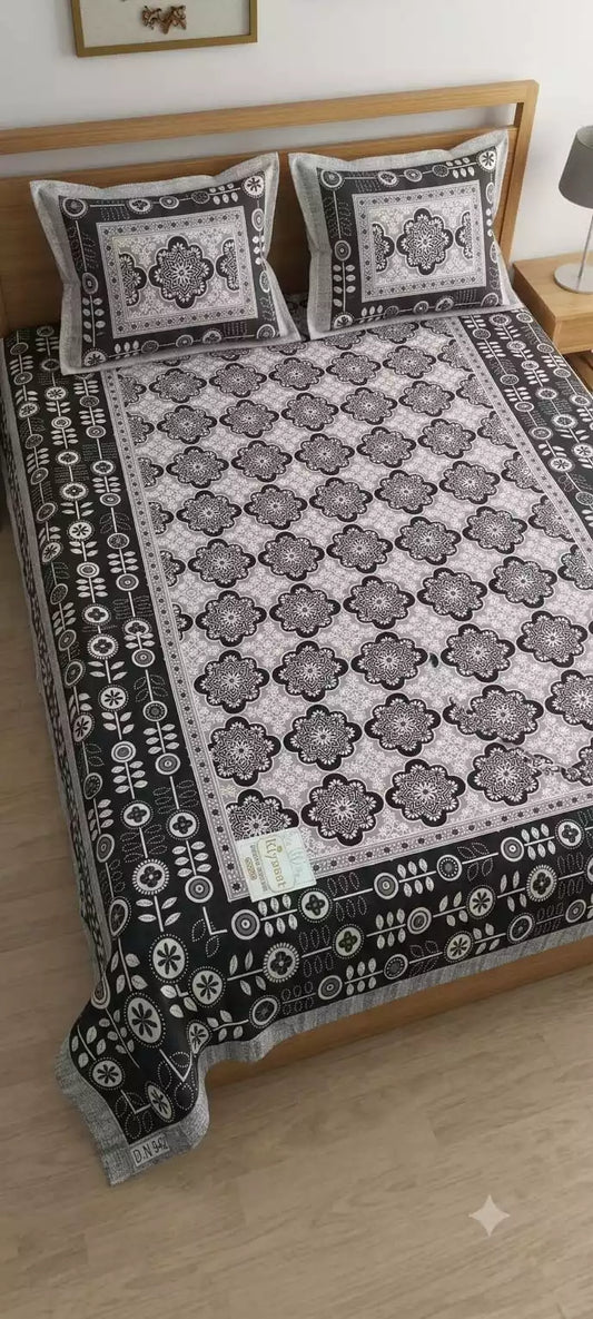 Jaipuri double bedsheet with pillow covers in black and white design displayed on a wooden bed.